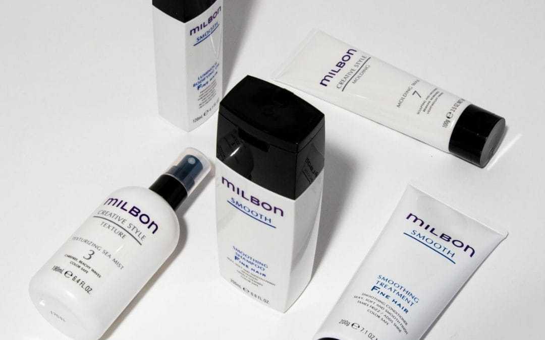 Milbon hair care products arranged on a white surface, featuring various bottles and tubes.