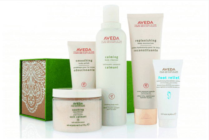 Aveda skincare products arranged with green box backdrop.